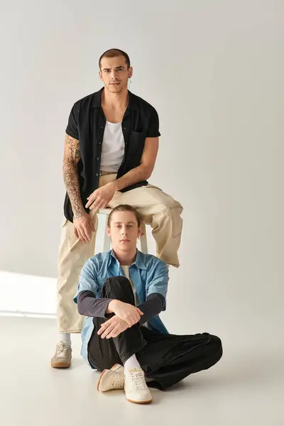 Two men sitting in a harmonious pose, showcasing balance and intimacy. — Stock Photo
