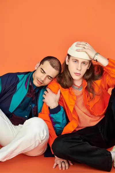 Two young men, an appealing loving gay couple, sit closely next to each other. — Stock Photo