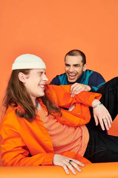 Два чоловіки сидять на підлозі, розділяючи момент сміху. — стокове фото
