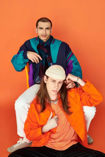 A man perched atop a chair beside his boyfriend. — Stock Photo