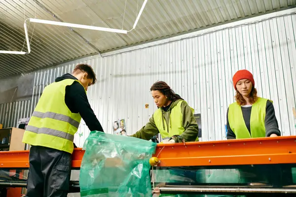 Young volunteers in gloves and safety vests sorting trash together for a cleaner environment. - foto de stock