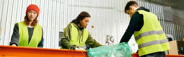 Young volunteers in gloves and safety vests sort trash, showing eco-conscious efforts to make a difference. — Foto stock