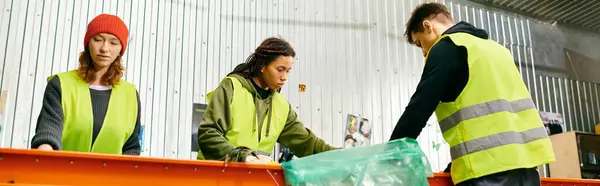 Young volunteers in gloves and safety vests sort trash, showing eco-conscious efforts to make a difference. — Stock Photo