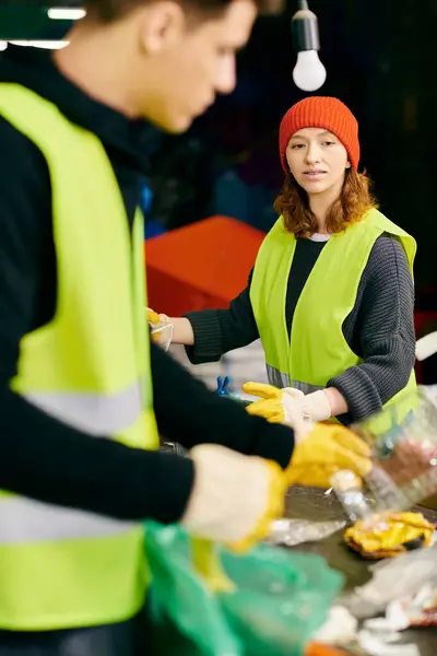 Young volunteers in gloves and safety vests standing together, sorting trash. — Stock Photo