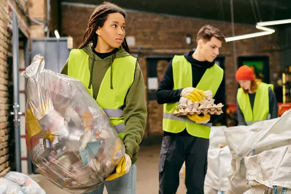 Young volunteers in gloves and safety vests sorting trash. — Stock Photo
