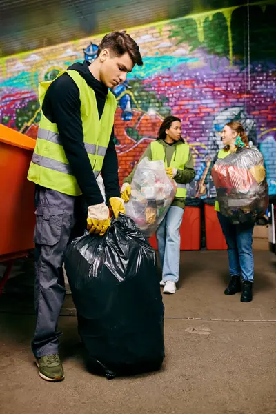 Young volunteers in safety vests and gloves sorting trash for a cleaner environment. — Fotografia de Stock
