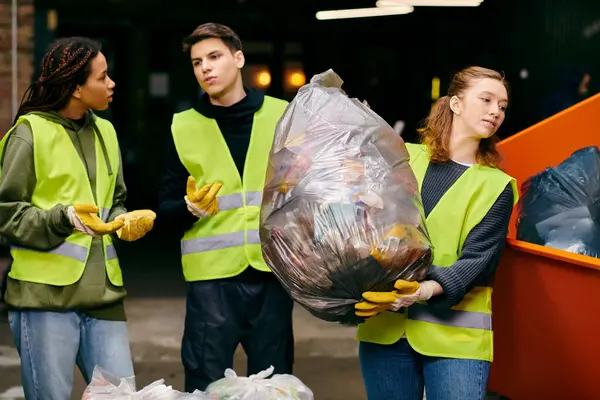 Young volunteers in gloves and safety vests stand together, sorting trash in a united effort towards sustainability. - foto de stock