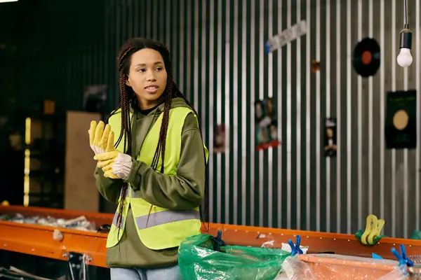 A young african american volunteer in gloves and safety vest — стокове фото