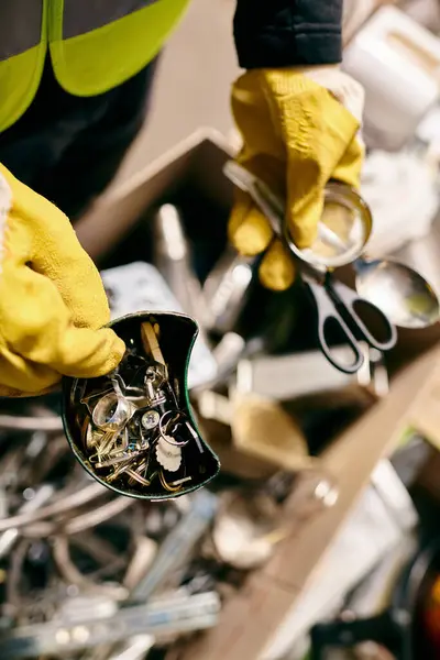 A young volunteer in yellow gloves cuts with scissors while sorting waste for recycling. — Fotografia de Stock