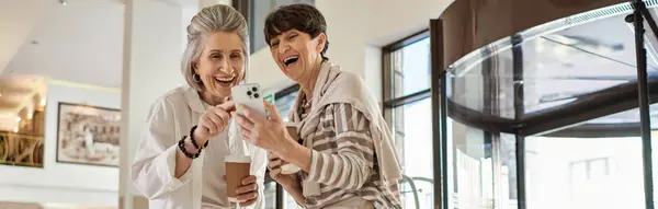 A senior lesbian couple standing together in a hotel, radiating love and tenderness. — Stock Photo