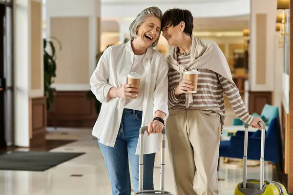 Un moment tendre partagé par un couple lesbienne senior dans un hôtel. — Photo de stock