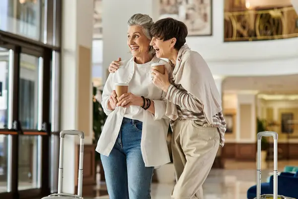Senior lesbian couple sharing a tender moment together in a hotel. — Stock Photo