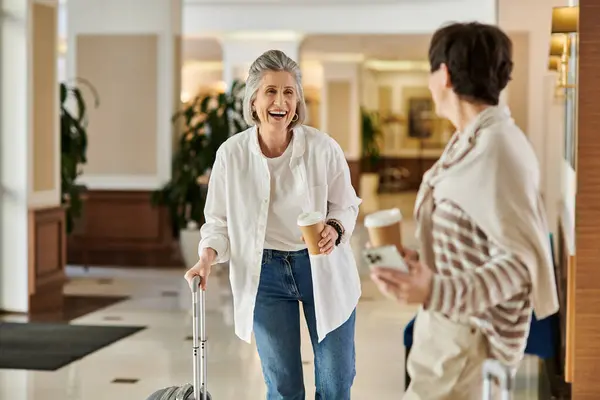 Senior lesbian couple walks with her luggage. — Stock Photo