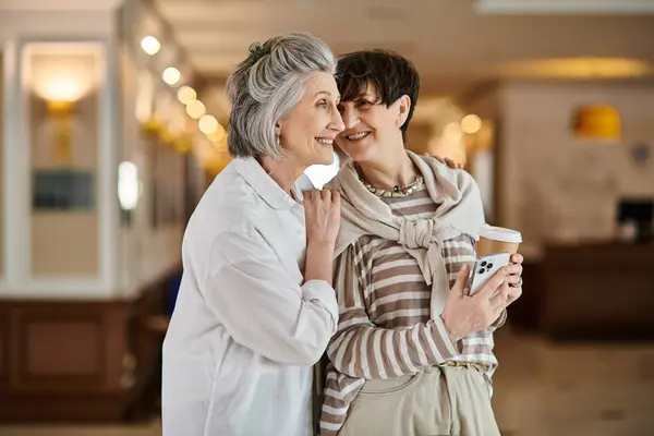 A tender moment between two senior lesbian partners in a hotel. — Stock Photo