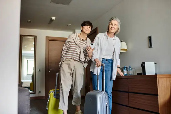 Couple lesbien senior avec valises, prêt pour leur prochaine aventure. — Photo de stock