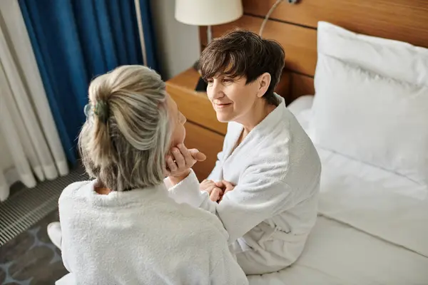 Senior coppia lesbica condivisione di un tenero momento su un letto. — Foto stock
