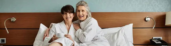 Un momento tenero tra una coppia lesbica anziana amorevole mentre giacevano a letto insieme. — Foto stock