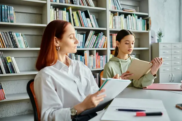 A redhead tutor passionately teaches a teenage girl in a cozy library setting, immersed in after-school lessons with a laptop. — Stock Photo