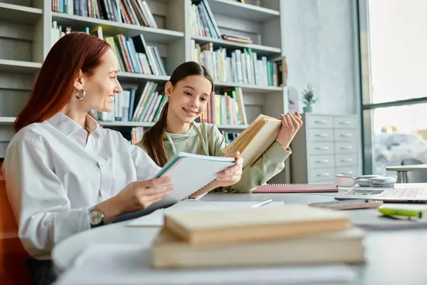 A tutor with red hair, engrossed in books at a library table, embracing the joy of learning after school. — Stock Photo