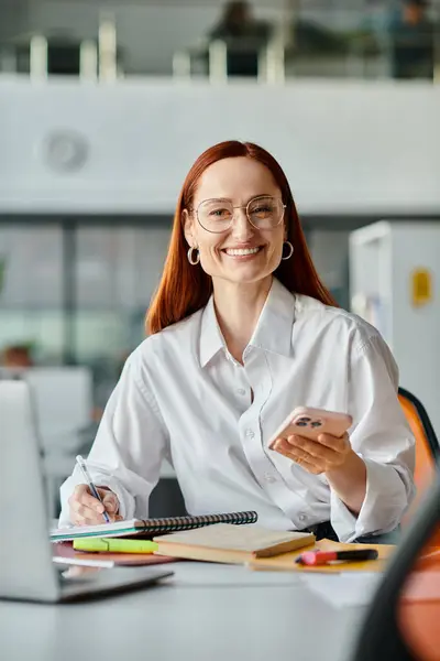 Redhead weibliche Tutorin Unterricht online, mit einem Laptop und Handy für die After-School-Lektion. — Stockfoto