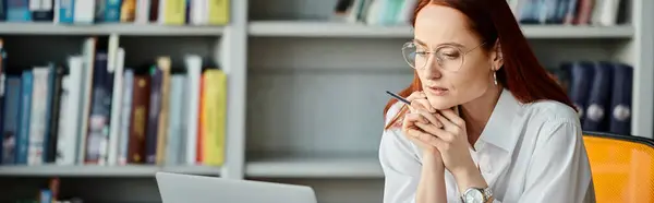 Eine rothaarige Tutorin unterrichtet fleißig online mit einem Laptop während einer After-School-Stunde. — Stockfoto