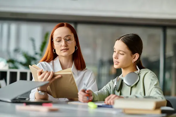 Rossa tutor donna adolescente ragazza a un tavolo con un libro, impegnarsi in lezioni post-scuola, migliorare l'istruzione moderna. — Foto stock