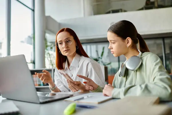 A redhead woman teaches a teenage girl, tutoring after school lessons together using a laptop. — Stock Photo