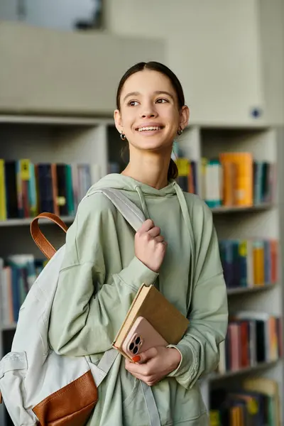 A teenage girl with a backpack full of books explores the library, eager to learn — Stock Photo