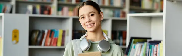 A teenage girl with a book in a library setting, modern education. — Stock Photo