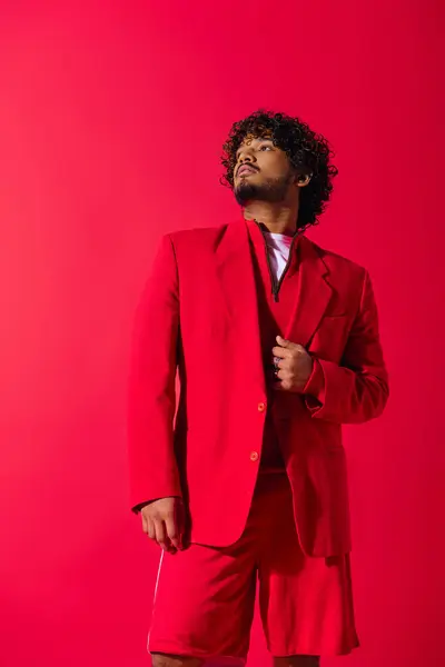 Schöner junger indischer Mann in einem auffallend roten Anzug, der Selbstvertrauen und Stil ausstrahlt. — Stockfoto
