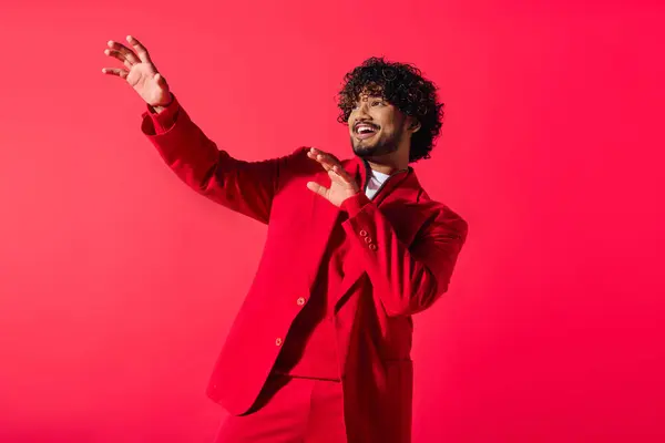 Bonito jovem indiano em um terno vermelho e camisa branca posando em um cenário vívido. — Fotografia de Stock