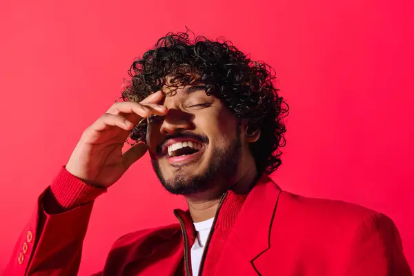 Young Indian man in red jacket having a phone conversation. — Stock Photo