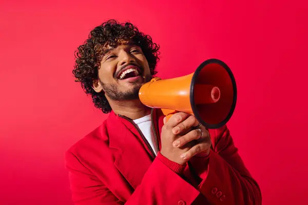 Handsome man holding red and orange megaphone. — Stock Photo