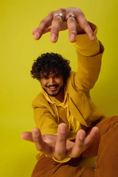 A man sitting on the ground with his hands raised in the air. — Stock Photo