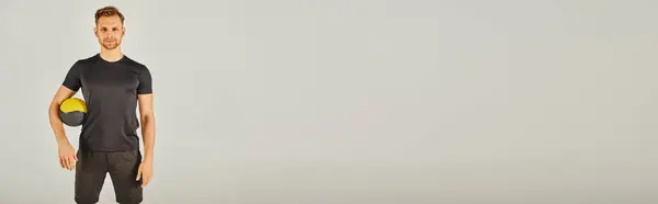 A man in active wear stands confidently in front of a white background. — Stock Photo