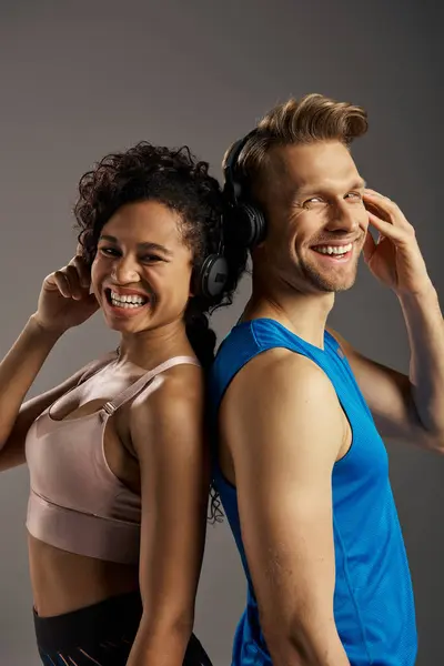Ein junges multikulturelles Paar in aktiver Kleidung lächelt mit Kopfhörern. — Stockfoto