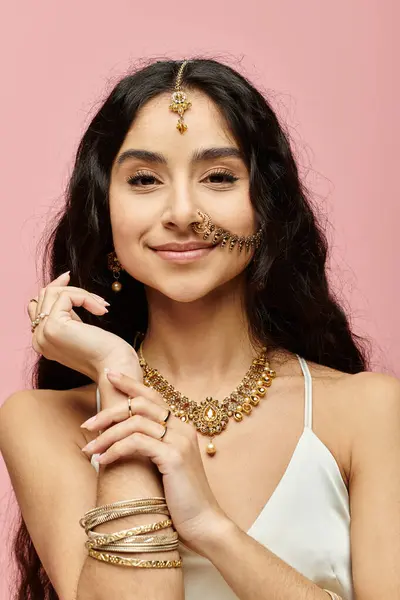 A captivating indian woman with long hair and gold jewelry striking a pose. — Stock Photo