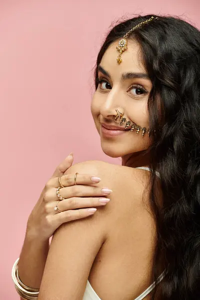 Young indian woman flaunting long hair and elegant gold jewelry in a captivating pose. — Stock Photo