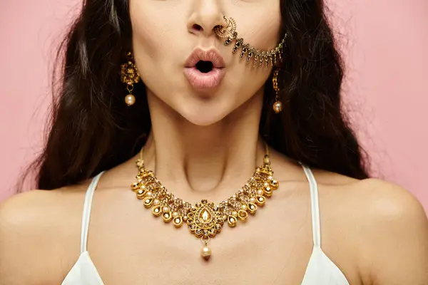 Зачарована індійська жінка, прикрашена золотими прикрасами, підбиває ніс. — стокове фото