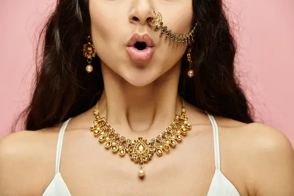 An alluring indian woman adorned in gold jewelry flaunts a nose piercing. — Stock Photo