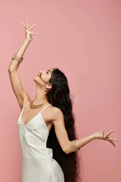 Young indian woman in white dress stretches arms gracefully. — Stock Photo