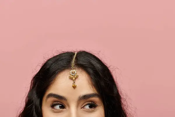 Elegant indian woman showcasing a stunning gold tiara. — Stock Photo