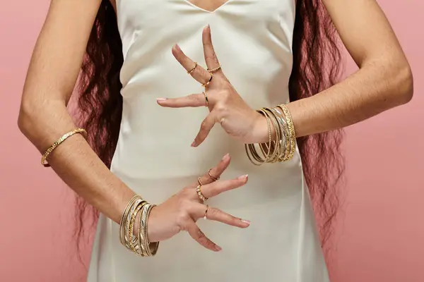 Классическая индианка в белом платье, украшенном золотыми кольцами, занимает захватывающую позу.. — стоковое фото