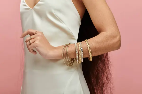 Uma mulher indiana elegante brilha em um vestido branco adornado com belas pulseiras de ouro. — Stock Photo