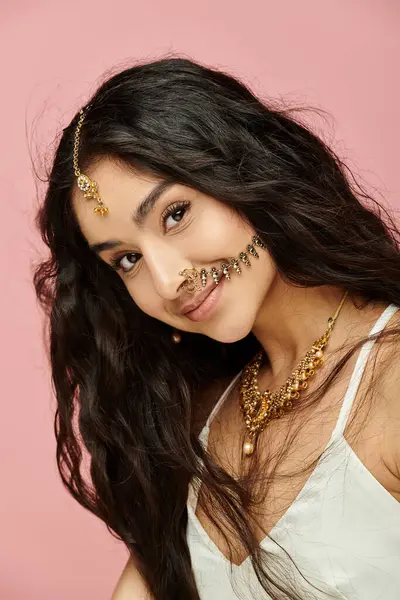 Mulher indiana jovem com cabelos longos e jóias de ouro posa elegantemente para a câmera. — Stock Photo