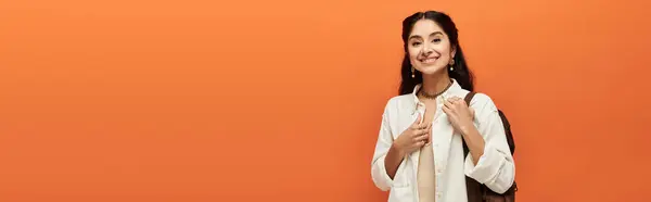 A indian woman beams with joy on a vibrant orange backdrop. — Stock Photo