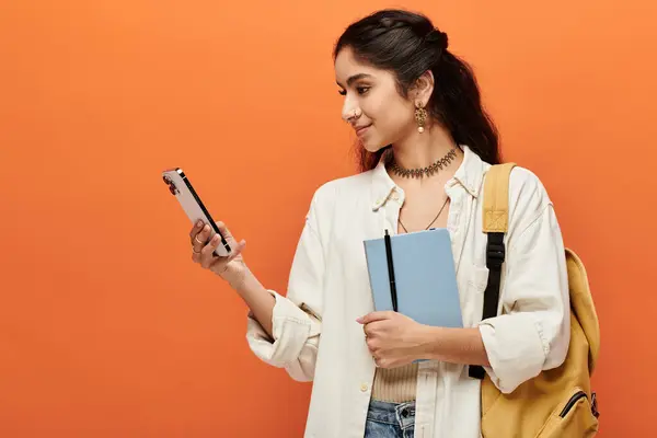 Young indian woman holding backpack, checking phone. — Stock Photo