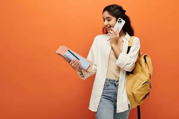 Young indian woman engaging in a phone call while carrying a backpack. — Stock Photo
