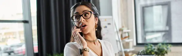 A stylish indian woman in glasses converses on her phone. — Stock Photo