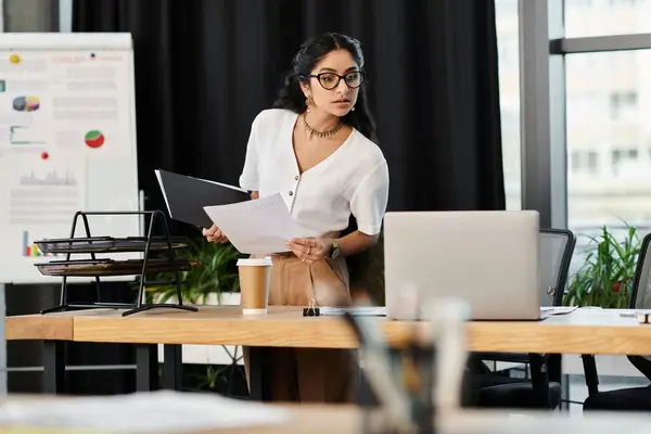 Una mujer india equilibrada se levanta asertivamente ante un escritorio de la oficina. — Stock Photo